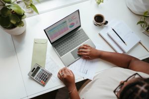 Self-employed person working at a laptop at home, managing income for a Universal Credit claim